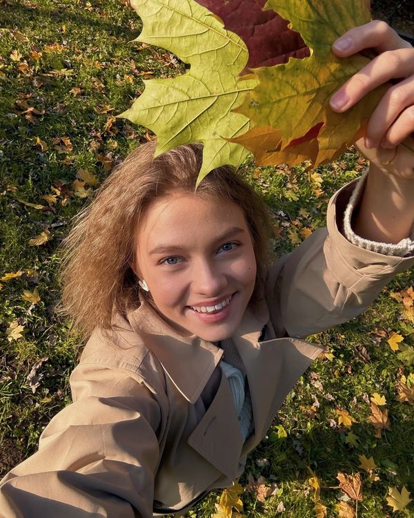 Саша Квашеная осенью пытается повесить упавший листик обратно на дерево