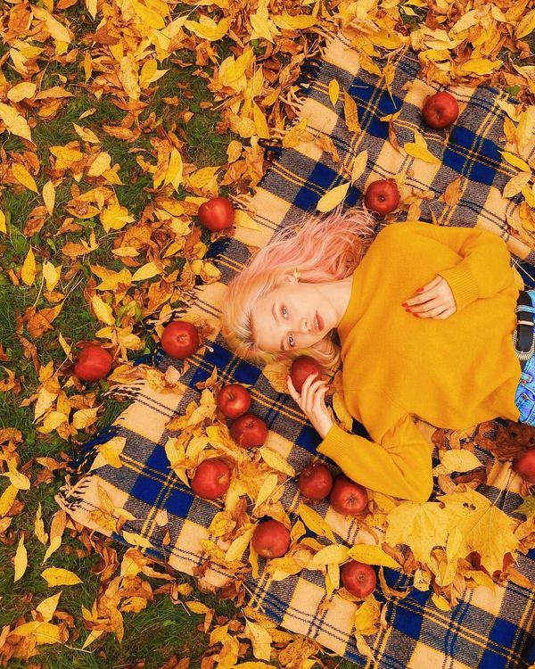 Саша Квашеная осенью лежит рядом с яблоками и желтыми листьями