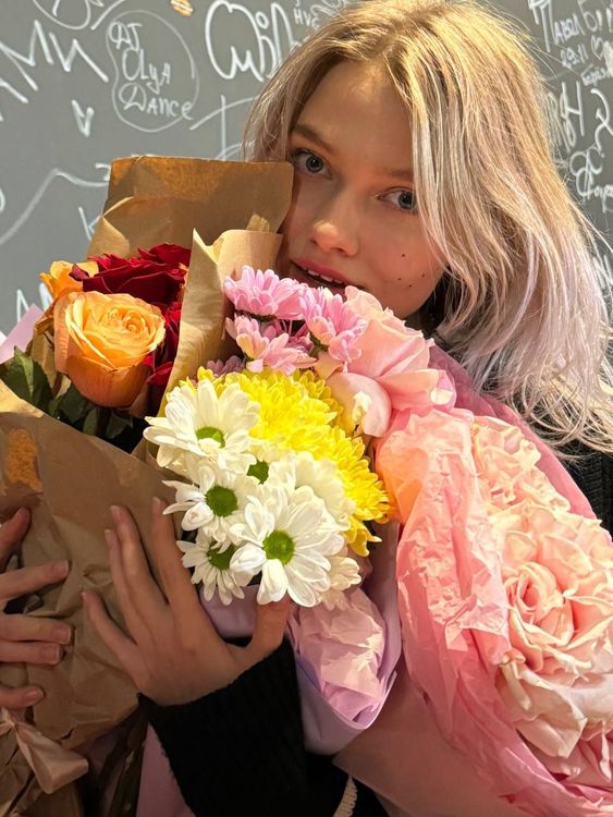 Саша Квашеная с букетами цветов после концерта