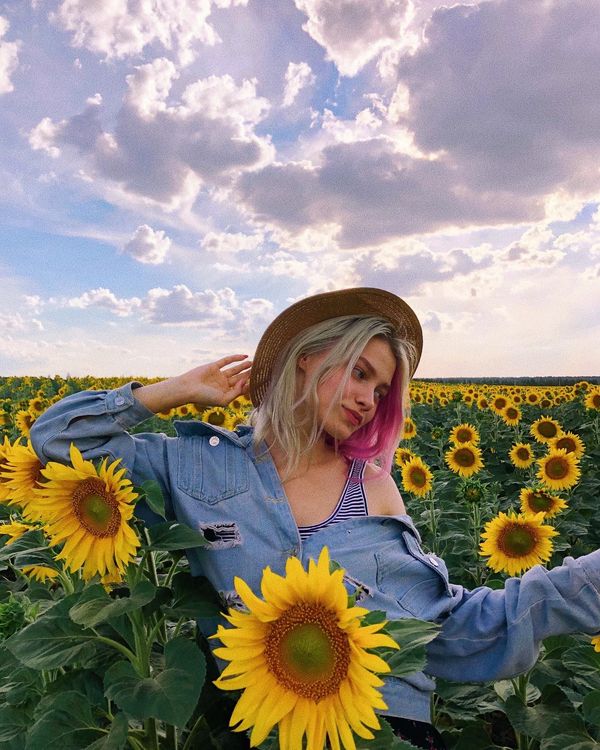 Саша Квашеная в шляпке в огромном поле с подсолнечниками